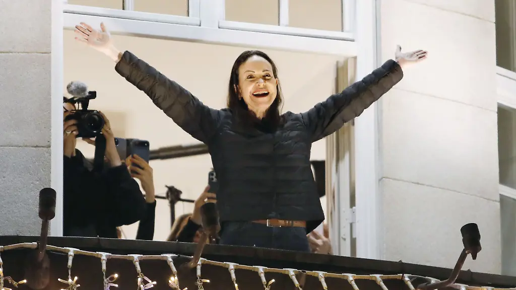 Venezuelan-opposition-leader-Maria-Corina-Machado-winner-of-the-2025-Nobel-Peace-Prize-acknowledges-a-crowd-of-people-from-the-balcony-of-Grand-Hotel-Oslo-after-arriving-in-the-Norwegian-capital-in-the-small-hours-of-Dec-11-The-award-ceremony-took-place-the-previous-day-with-her-daughter-Ana-Corina-Sosa-Machado-attending-on-her-behalf