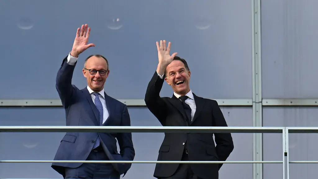 German-Chancellor-Friedrich-Merz-and-NATO-Secretary-General-Mark-Rutte-wave-from-the-terrace-of-the-Chancellery-at-a-group-of-young-people-on-the-courtyard-in-Berlin-Germany-December-11-2025