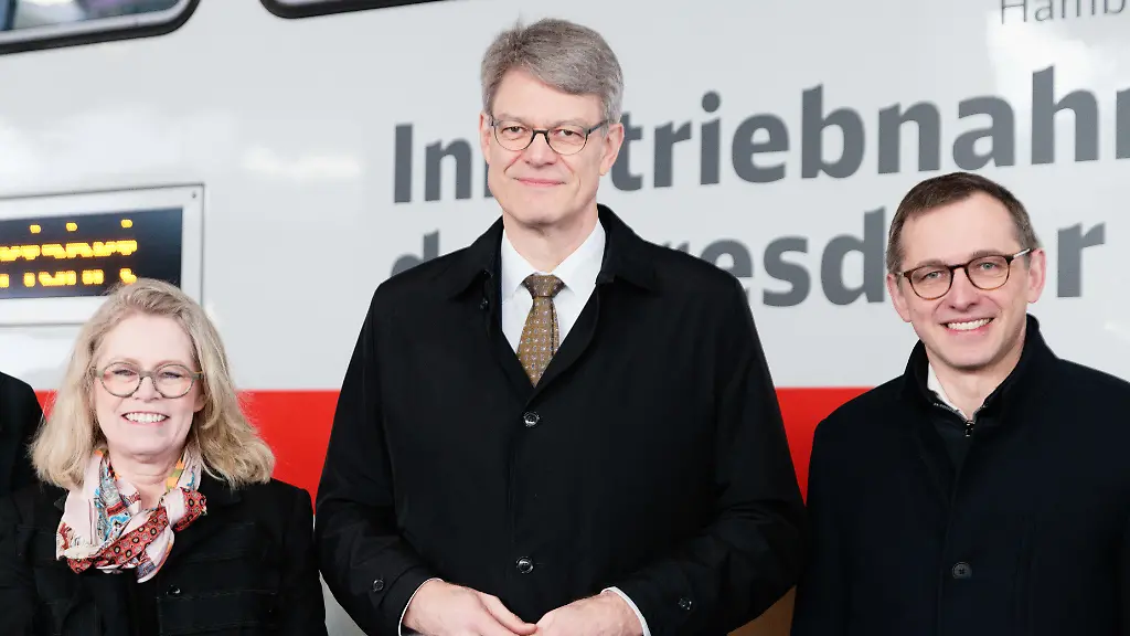 Ute-Bonde-CDU-l-r-Senatorin-fuer-Mobilitaet-Verkehr-Klimaschutz-und-Umwelt-von-Berlin-Patrick-Schnieder-CDU-Bundesminister-fuer-Verkehr-und-Philipp-Nagl-Vorsitzender-des-Vorstands-DB-InfraGO-AG-stehen-anlaesslich-der-Inbetriebnahme-der-Dresdner-Bahn-auf-Berliner-Gebiet-vor-dem-Sonderzug-Mit-der-Oeffnung-der-sogenannten-Dresdner-Bahn-im-Sueden-Berlins-verkuerzt-sich-die-Fahrzeit-vom-Hauptbahnhof-zum-Flughafen-BER-ab-Mitte-Dezember-auf-20-Minuten