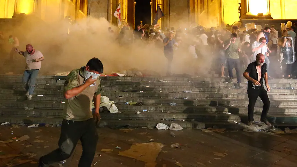 Demonstranten-fliehen-vor-dem-georgischen-Parlament-vor-von-Polizisten-abgefeuertem-Traenengas-Dort-fordern-die-Demonstranten-den-Ruecktritt-des-Parlamentspraesidenten-Bei-den-Protesten-sind-mehr-als-50-Menschen-verletzt-worden-Demonstranten-versuchten-zunaechst-vergeblich-das-Parlamentsgebaeude-zu-stuermen-Hintergrund-ist-lokalen-Medienberichten-zufolge-der-Besuch-einer-russischen-Delegation-bei-einer-Tagung-im-Plenarsaal-Dabei-habe-ein-Abgeordneter-der-russischen-Duma-den-Vorsitz-der-Tagung-zu-religioesen-und-politischen-Fragen-uebernommen