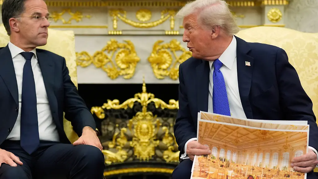President-Donald-Trump-holds-an-artist-rendering-of-the-interior-of-the-new-White-House-ballroom-as-meets-with-NATO-Secretary-General-Mark-Rutte-in-the-Oval-Office-of-the-White-House-Wednesday-Oct-22-2025-in-Washington