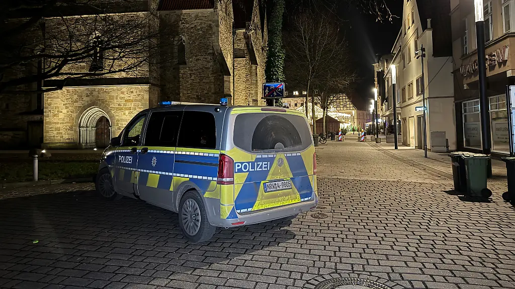 Ein-Polizeiauto-steht-in-der-Naehe-des-Weihnachtsmarktes-Ein-16-Jaehriger-ist-im-ostwestfaelischen-Herford-bei-einem-Messerangriff-lebensgefaehrlich-verletzt-worden-Der-Vorfall-habe-sich-in-einer-Seitenstrasse-am-Rande-des-Weihnachtsmarkts-ereignet-teilte-ein-Sprecher-der-Polizei-mit