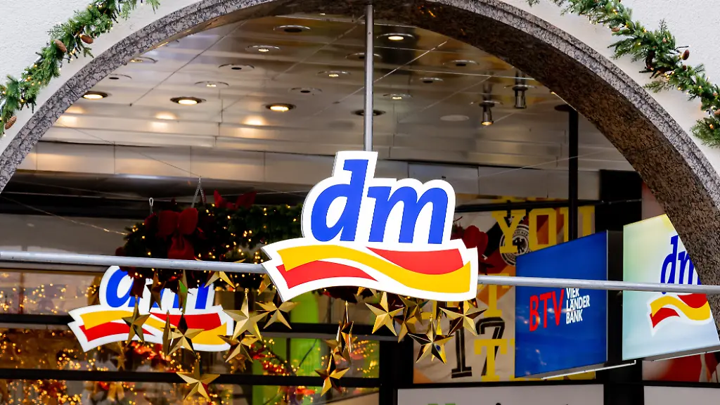 Logo-und-Schriftzug-der-Firma-dm-auf-einem-Schild-ueber-dem-Eingang-am-entsprechenden-Geschaeft-es-ist-bereits-vorweihnachtlich-geschmueckt-GER-Themenbild-Wirtschaft-Einzelhandel-in-der-Muencher-Innenstadt-18-11