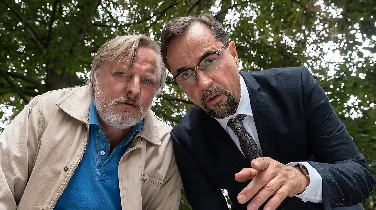 HANDOUT-Frank-Thiel-l-Axel-Prahl-und-Prof-Karl-Friedrich-Boerne-Jan-Josef-Liefers-beugen-sich-ueber-den-Toten-in-einer-Szene-aus-Tatort-Es-lebe-der-Koenig-undatiert-Der-Krimi-aus-Muenster-wird-am-02-05-2023-um-20-15-Uhr-im-BR-Fernsehen-ausgestrahlt