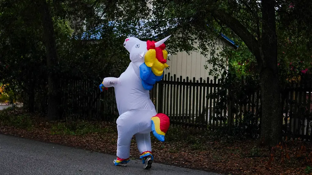 Entertainment-Bilder-des-Tages-April-16-2020-Tampa-Florida-USA-Corey-Jurgensen-runs-along-the-road-taking-small-steps-while-wearing-an-inflatable-unicorn-costume-Jurgensen-has-been-dressing-up-her-runs-several-times-a-week-to-cheer-up-others-during-this-time-of-isolation-but-finds-it-therapeutic-for-herself-as-well-to-run-through-her-Seminole-Heights-neighborhood-wearing-a-silly-costume-Thursday-April-16-2020-in-Tampa