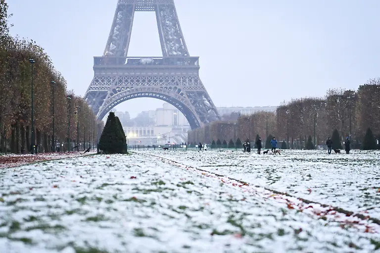 Pedestrians-walk-around-as-snow-covers-the-ground-around-the-Eiffel-Tower-in-Paris-France-on-November-23-2025-Photo-by-Firas-Abdullah-ABACAPRESS