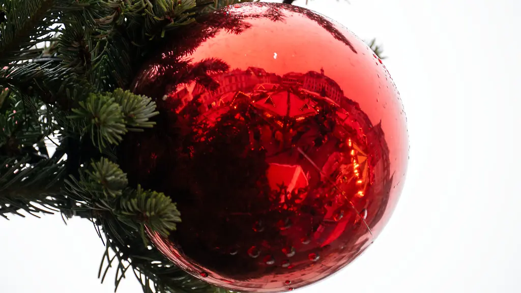 07-12-2025-Bayern-Coburg-Regentropfen-liegen-auf-einer-Christbaumkugel-in-der-sich-ein-Weihnachtsmarkt-spiegelt