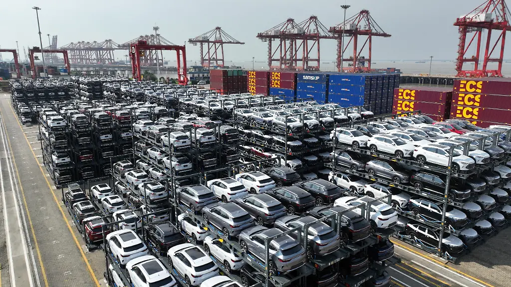 Eine-Luftaufnahme-zeigt-chinesische-Autos-mit-Hybrid-oder-Elektroantrieb-fuer-den-Export-in-einem-Terminal-des-Hafens-Taicang-in-der-ostchinesischen-Provinz-Jiangsu