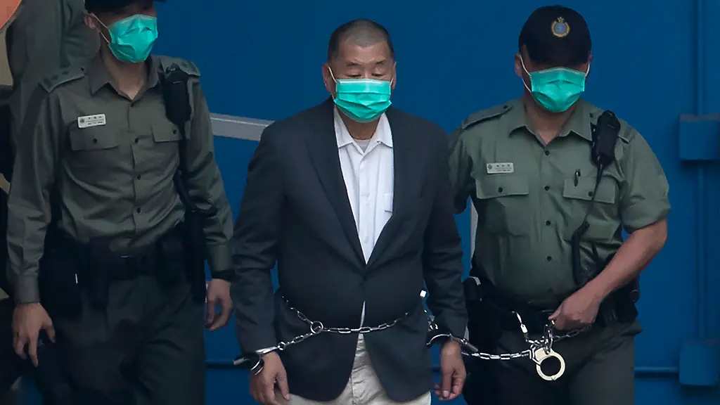 FILE-Hong-Kong-Hong-Kong-media-mogul-and-pro-democracy-activist-Jimmy-Lai-is-escorted-by-Correctional-Services-officers-to-get-on-a-prison-van-before-appearing-in-a-court-in-Hong-Kong-Dec-12-2020-Lawyers-for-Lai-are-asking-the-United-Nations-to-investigate-his-imprisonment-and-multiple-criminal-charges-as-legal-harassment-that-punish-him-for-speaking-out