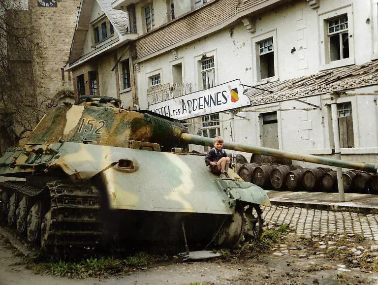 History-World-War-II-Western-Front-Bastogne-November-1945-Small-boy-sitting-on-the-wreck-of-a-tank-relic-from-the-Battle-of-Bastogne-between-trapped-US-troops-and-the-German-Wehrmacht-during-the-Battle-of-the-Bulge-19-Dec-1944-12-Jan-1945-Photo-16-Nov-1945