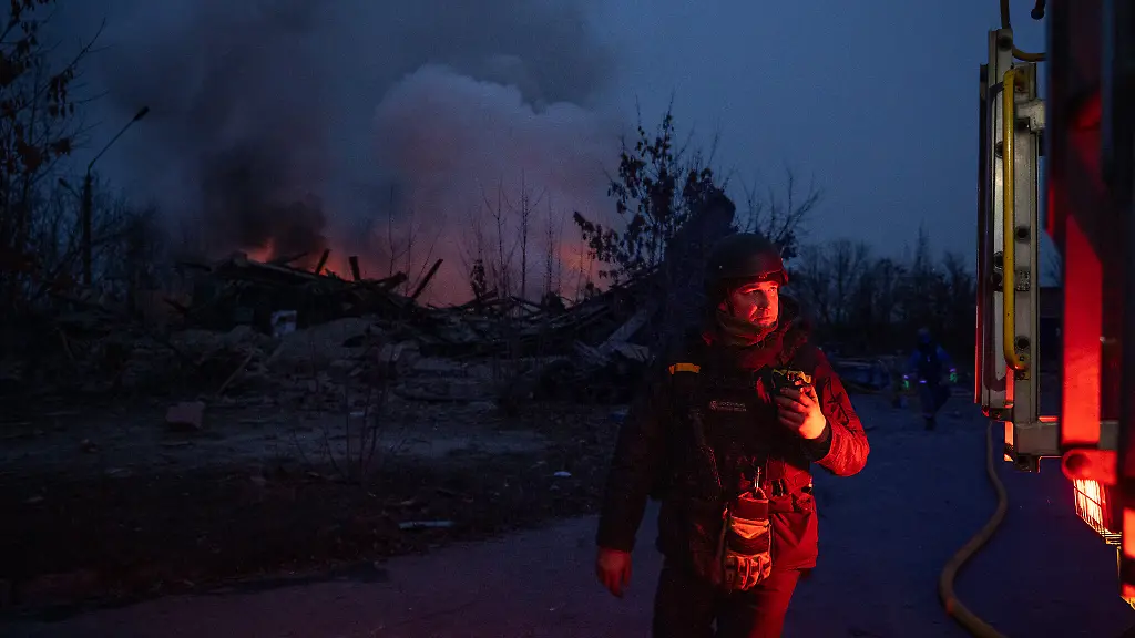 Feuerwehrleute-stehen-in-der-Naehe-der-Einschlagstelle-einer-russischen-Artilleriegranate-waehrend-schwarzer-Rauch-in-die-Luft-in-Kramatorsk-aufsteigt