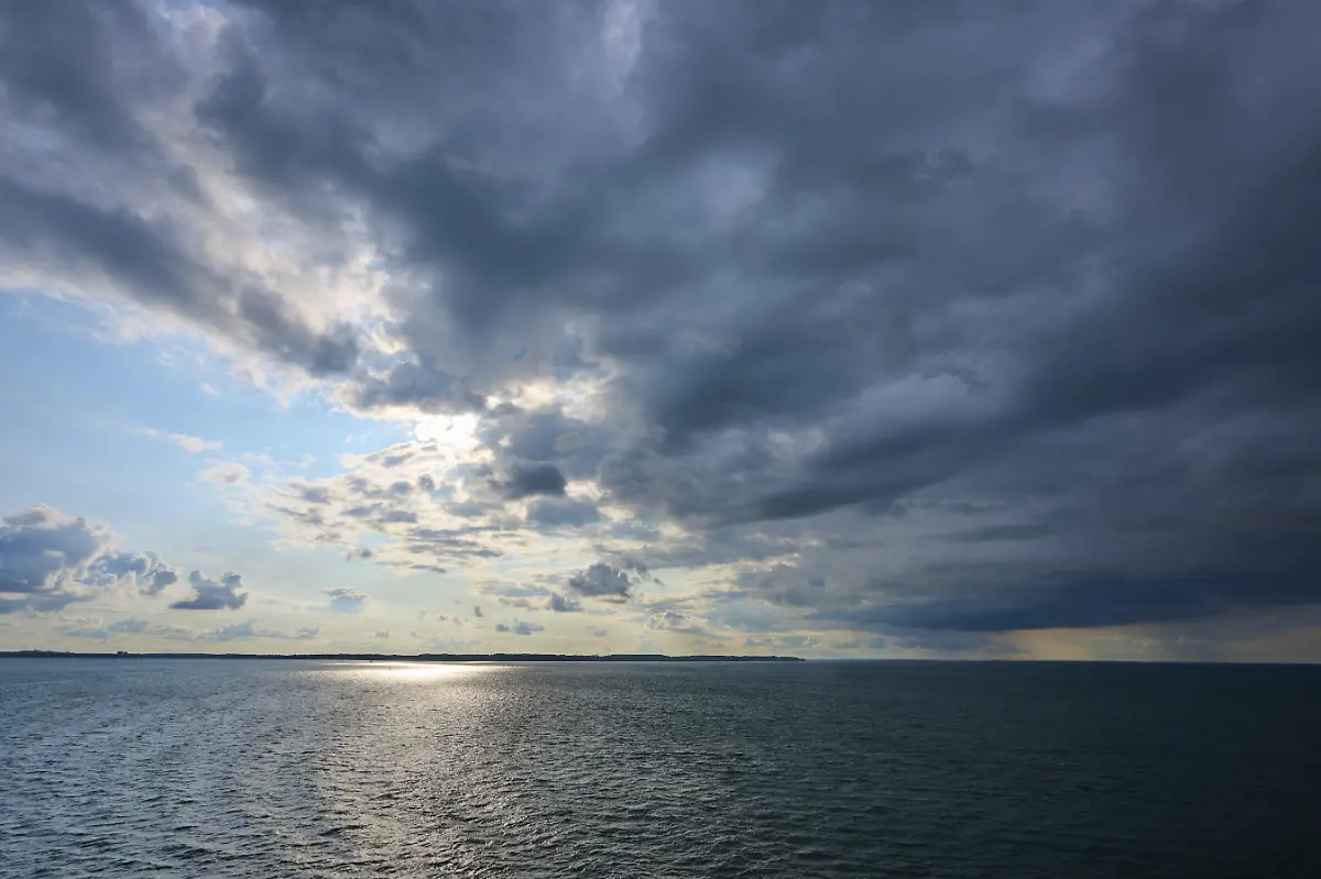 Dramatisch-bewoelkter-Himmel-ueber-der-Ostsee-durchbrochen-von-Sonnenstrahlen-Herbst-Kiel-Schleswig-Holstein-Deutschland-Europa