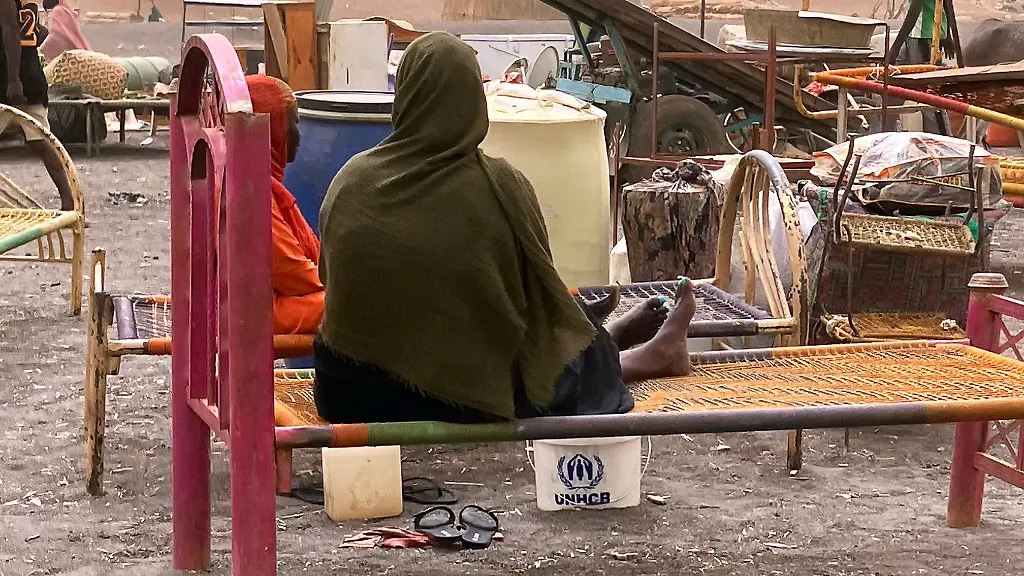 Gefluechtete-Frauen-aus-dem-dem-Sudan-mit-ihrer-Habe-Der-Machtkampf-im-Sudan-der-seit-Mitte-April-2023-andauert-hat-die-nach-UN-Angaben-weltweit-groesste-Fluechtlingskrise-mit-mehr-als-zwoelf-Millionen-Gefluechteten-ausgeloest-Menschenrechtsorganisationen-klagen-ueber-sexuelle-Gewalt-als-Kriegswaffe-Die-Hilfsorganisation-Aerzte-ohne-Grenzen-berichtet-es-gebe-kaum-sichere-Orte-fuer-Frauen-und-Maedchen-in-den-Kampfgebieten