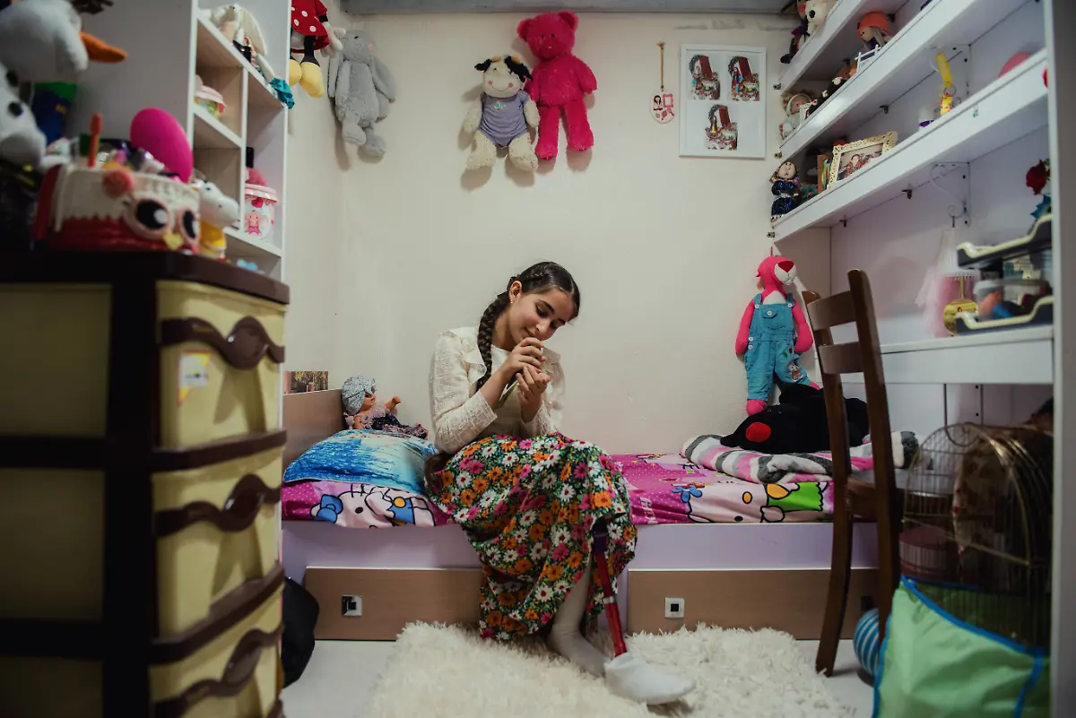 Yeganeh-Farjam-12-sits-in-her-room-with-her-bird-at-home-in-Tehran-Iran-on-October-12-2025-Yeganeh-who-wears-a-prosthetic-leg-continues-her-rehabilitation-and-daily-activities-with-determination-and-support-from-her-family