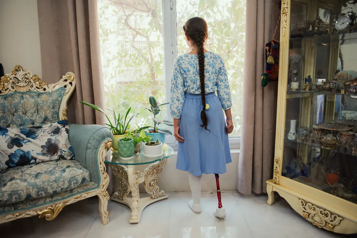 Yeganeh-Farjam-12-looks-out-the-window-at-her-home-in-Tehran-Iran-on-October-12-2025-Yeganeh-who-wears-a-prosthetic-leg-continues-her-rehabilitation-and-daily-activities-with-determination-and-support-from-her-family
