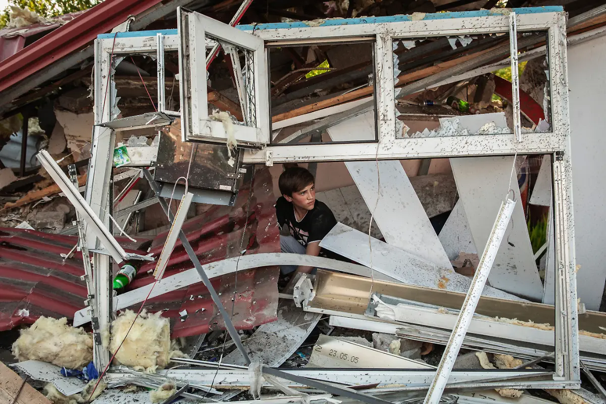 Kramatorsk-2014-A-child-is-seen-inside-the-ruins-of-a-small-shop-destroyed-by-artillery