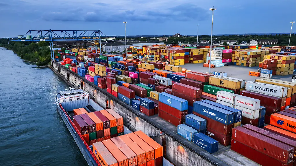 ARCHIV-30-07-2025-Nordrhein-Westfalen-Duisburg-Container-werden-im-Duisburger-Hafen-auf-Binnenschiffe-verladen-Die-Deutsche-Wirtschaft-geht-nach-Prognose-der-Industriestaatenorganisation-OECD-ab-kommendem-Jahr-wieder-langsam-auf-Wachstumskurs