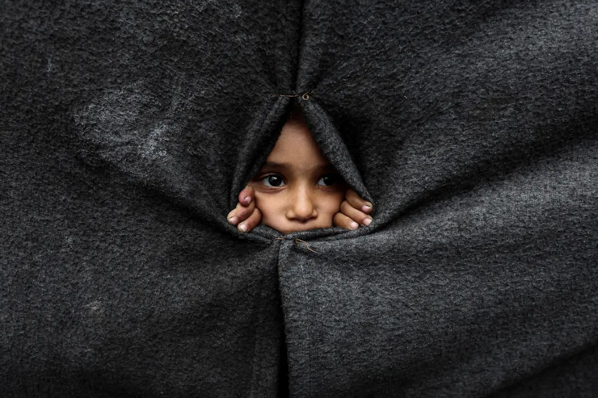 A-displaced-Palestinian-child-looks-through-a-covering-made-from-blankets-as-they-take-shelter-at-an-UNRWA-run-school-after-U-S-President-Donald-Trump-announced-that-Israel-and-Hamas-agreed-on-the-first-phase-of-a-Gaza-ceasefire-in-Khan-Younis-in-the-southern-Gaza-Strip-October-9-2025-REUTERS-Ramadan-Abed-TPX-IMAGES-OF-THE-DAY-SEARCH-REUTERS-BEST-2025-FOR-THIS-STORY-SEARCH-REUTERS-2025-YEAR-END-FOR-ALL-2025-YEAR-END-GALLERIES