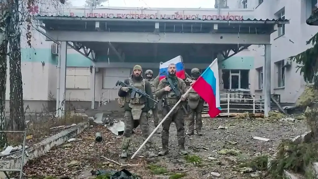 Russia-Ukraine-Military-Operation-Kupyansk-9051541-21-11-2025-In-this-handout-video-grab-released-by-the-Russian-Defence-Ministry-Russian-servicemen-of-Zapad-West-group-of-forces-hold-national-flags-in-a-street-in-the-town-of-Kupyansk-amid-Russia-s-military-operation-in-Ukraine-in-Kharkov-Kharkiv-region-Ukraine-Kupyansk-was-taken-under-control-as-a-result-of-active-operations-of-the-Zapad-West-group-of-forces-the-Russian-Defence-Ministry-said-on-November-21-Sputnik-Image-is-a-handout-provided-by-a-third-party-Editorial-use-only-No-archiving-commercial-use-or-advertising-campaign