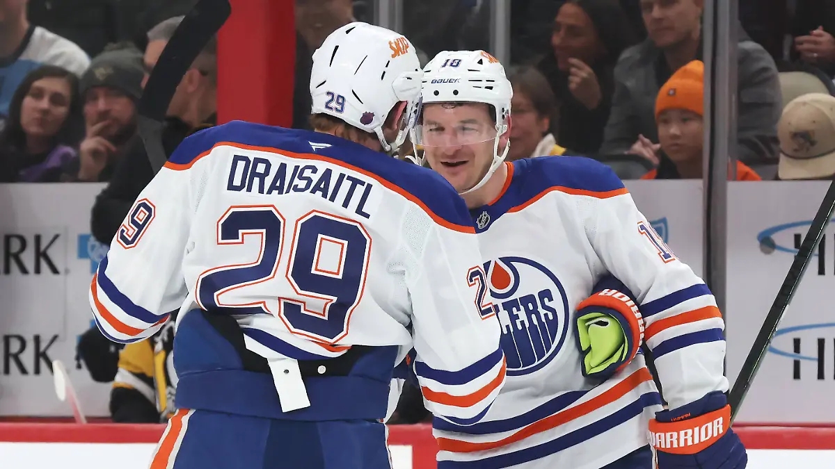 NHL-Eishockey-Herren-USA-Edmonton-Oilers-at-Pittsburgh-Penguins-Dec-16-2025-Pittsburgh-Pennsylvania-USA-Edmonton-Oilers-left-wing-Zach-Hyman-18-congratulates-center-Leon-Draisaitl-29-on-his-1000th-career-NHL-point-which-was-an-assist-against-the-Pittsburgh-Penguins-during-the-first-period-at-PPG-Paints-Arena