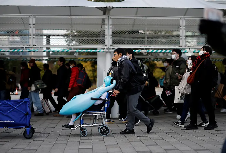 Akihiko-Kondo-43-who-in-2018-married-Hatsune-Miku-a-virtual-pop-idol-carries-a-life-size-doll-of-the-character-as-he-heads-to-set-up-a-booth-promoting-marriage-with-two-dimensional-characters-at-the-comic-convention-Comiket-in-Tokyo-Japan-December-30-2024-REUTERS-Kim-Kyung-Hoon-SEARCH-JAPAN-KYUNG-HOON-AI-WEDDING-FOR-THIS-STORY-SEARCH-WIDER-IMAGE-FOR-ALL-STORIES