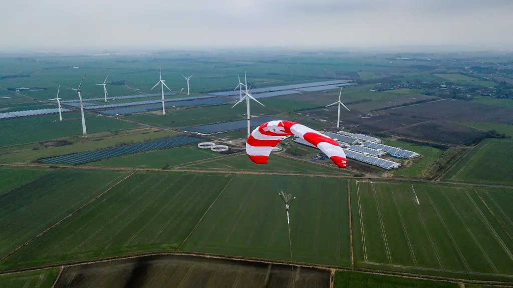 Der-Schirm-einer-Skysails-Anlage-schwebt-ueber-den-Aeckern-der-norddeutschen-Stadt-Klixbuell