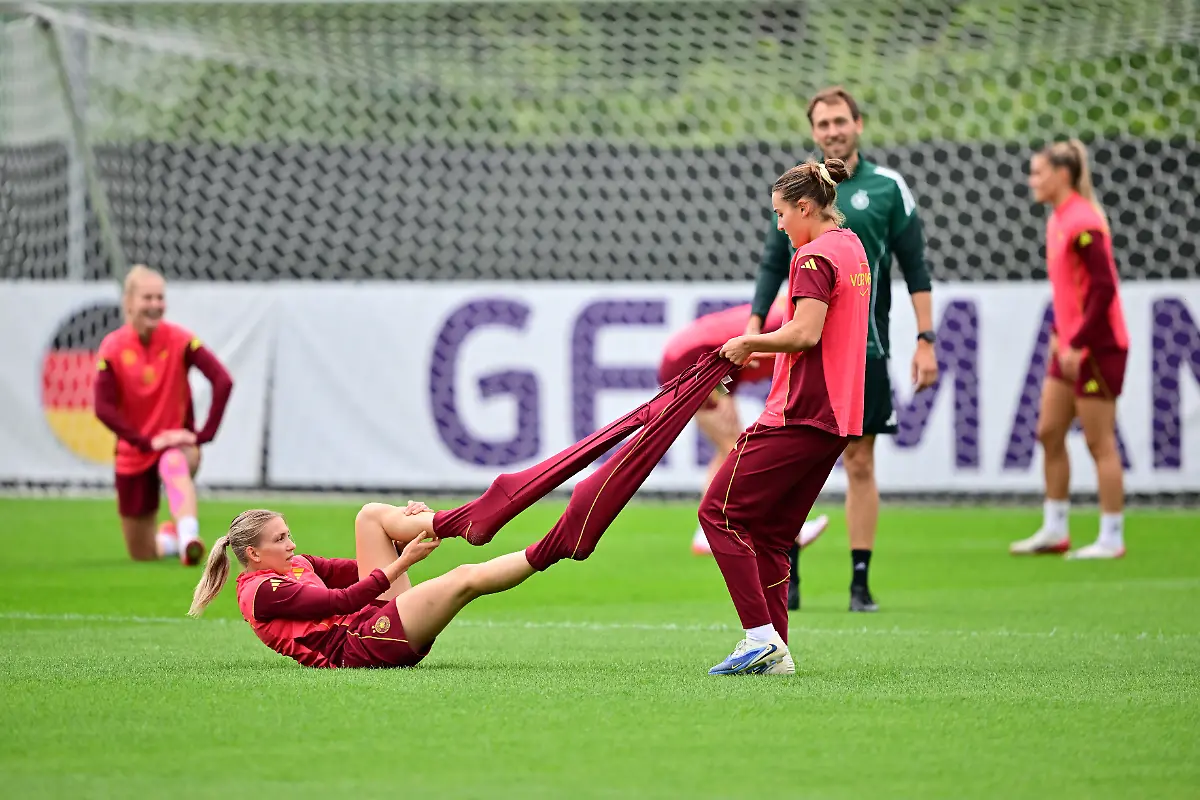 Fussball-Frauen-EM-Vor-dem-Halbfinale-Spanien-Deutschland-Training-Deutschland-Deutschlands-Elisa-Senss-l-bekommt-von-Carlotta-Wamser-Hilfe-beim-Ausziehen-der-langen-Sporthose