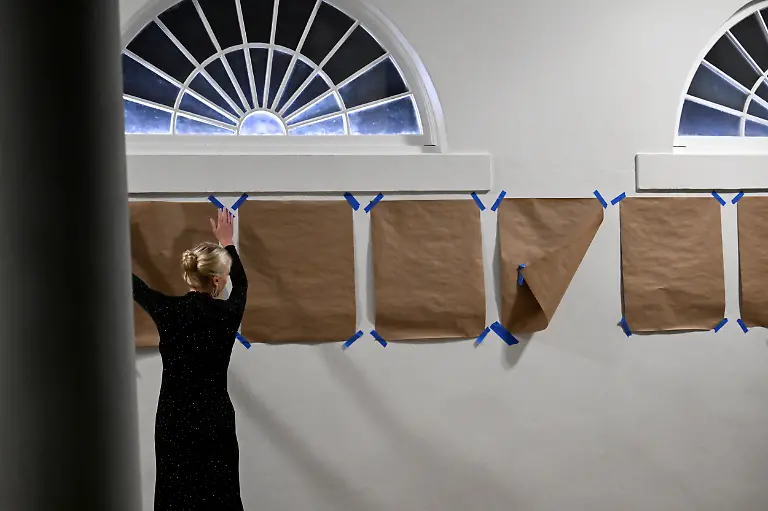 White-House-Aide-Natalie-Harp-fixes-brown-papers-pasted-below-the-writing-Presidental-Walk-of-Fame-on-the-wall-next-to-the-Rose-Garden-after-arriving-with-President-Donald-Trump-at-the-White-House-on-Marine-One-in-Washington-D-C-U-S-September-20-2025