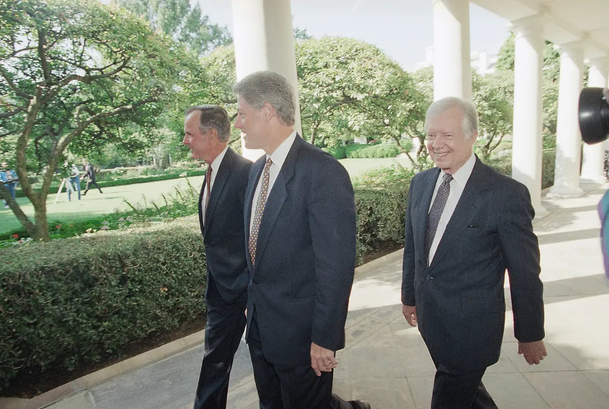 FILE-U-S-President-Bill-Clinton-flanked-by-former-Presidents-George-Bush-left-and-Jimmy-Carter-walks-through-the-Colonnades-of-the-White-House-Washington-on-Sept-13-1993