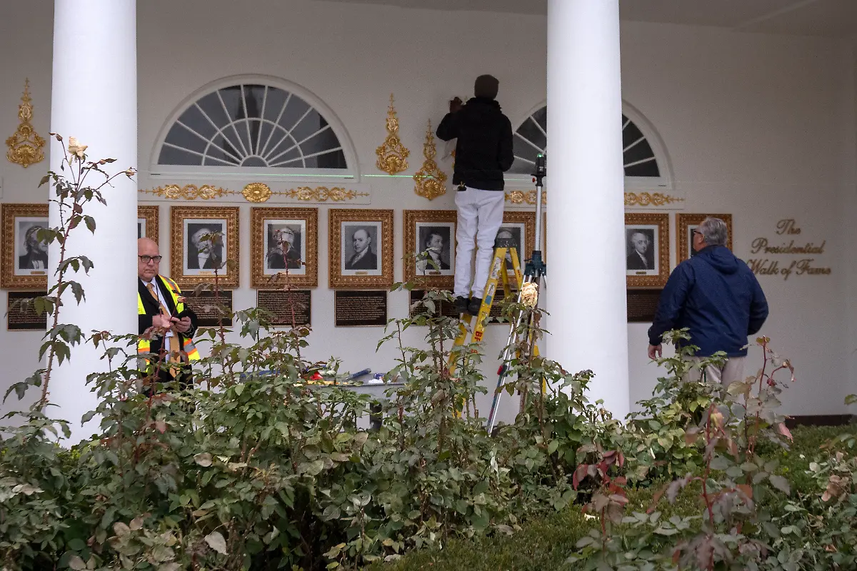 Workers-use-a-laser-level-to-install-decorative-elements-on-the-Presidential-Walk-of-Fame-on-the-Colonnade-of-the-White-House-Wednesday-Dec-17-2025-in-Washington