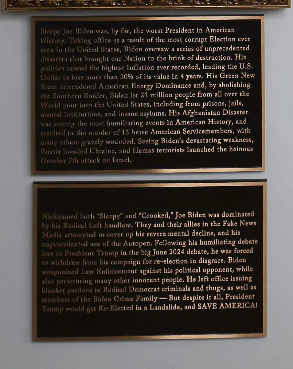 Plaques-disparaging-former-U-S-President-Joe-Biden-are-seen-under-an-image-of-an-autopen-signing-Biden-s-signature-on-the-Presidential-Walk-of-Fame-along-the-White-House-Colonnade-in-Washington-D-C-U-S-December-17-2025