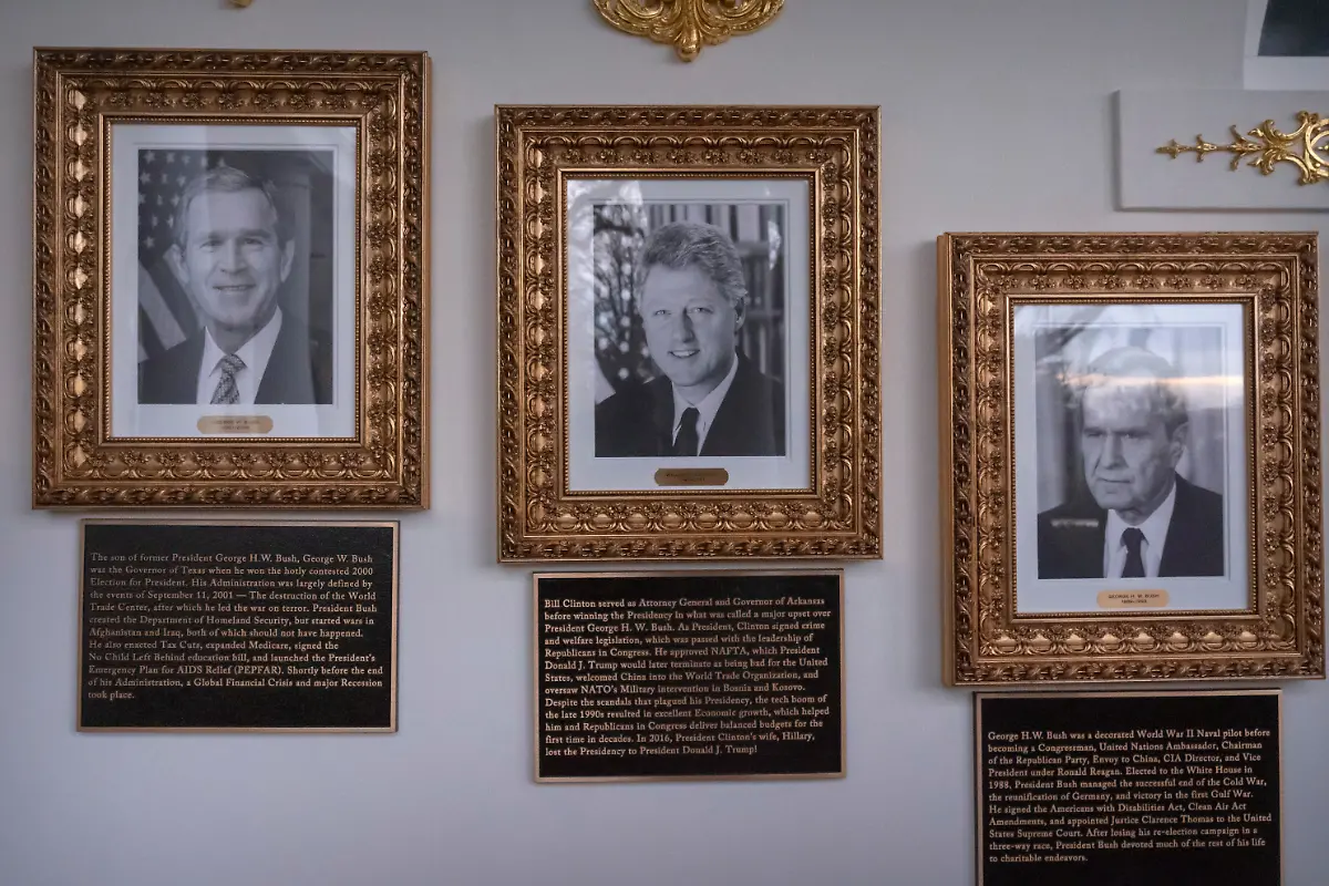 Portraits-of-former-Presidents-George-W-Bush-Bill-Clinton-and-George-H-W-Bush-with-plaques-of-text-below-are-seen-on-the-Presidential-Walk-of-Fame-on-the-Colonnade-of-the-White-House-Wednesday-Dec-17-2025-in-Washington
