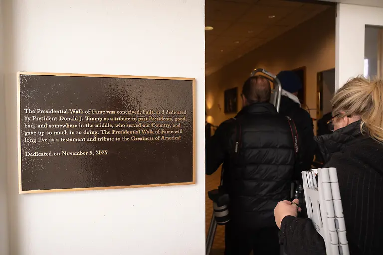 Members-of-the-press-walk-past-a-plaque-near-the-Presidential-Walk-of-Fame-at-the-White-House-Wednesday-Dec-17-2025-in-Washington