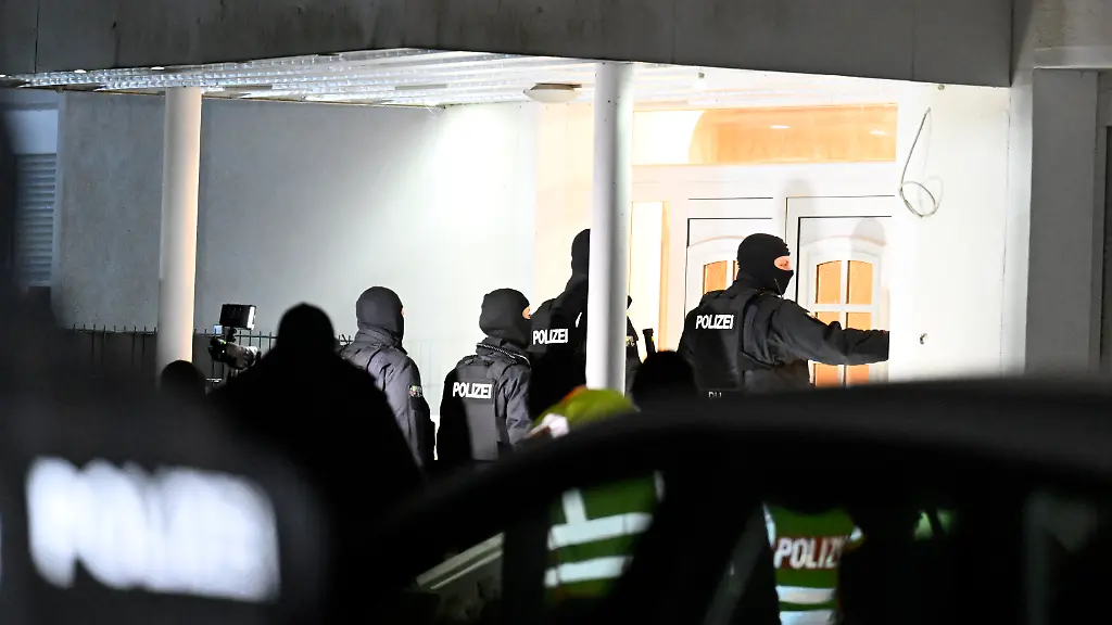 Polizisten-dringen-im-Rahmen-einer-gross-angelegten-Razzia-in-ein-Haus-ein-Mit-der-bundesweiten-Aktion-geht-die-Polizei-gegen-Mitglieder-des-Al-Zein-Clans-vor-Mehr-als-50-Beschuldigten-wird-nach-dpa-Informationen-unter-anderem-die-Unterschlagung-zahlreicher-Autos-vorgeworfen