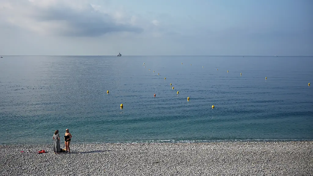 Frauen-unterhalten-sich-vor-der-UN-Ozeankonferenz-am-Strand-an-der-franzoesischen-Riviera-57-Jahre-nach-einem-Flugzeugabsturz-vor-Nizza-mit-95-Toten-haben-Polizeitaucher-Wrackteile-der-Maschine-geortet-bei-der-die-Justiz-den-Verdacht-eines-versehentlichen-Abschusses-durch-die-franzoesische-Armee-prueft
