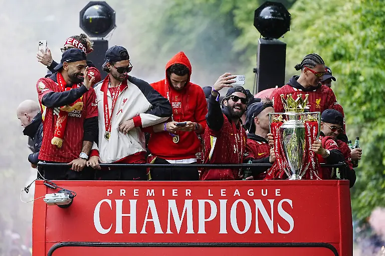 Liverpools-Mohamed-Salah-links-Dominik-Szoboszlai-zweiter-von-links-Torhueter-Alisson-Becker-mit-der-Trophaee-Mitte-rechts-und-Teamkollegen-im-Mannschaftsbus-waehrend-der-Premier-League-Siegerparade-in-Liverpool-Liverpool-sicherte-sich-Ende-des-vergangenen-Monats-den-zweiten-Titel-in-35-Jahren