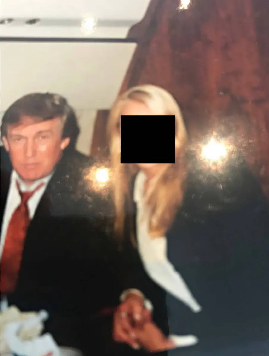 DATE-and-LOCATION-UNIDENTIFIED-One-of-80-images-released-December-12-2025-of-the-95-000-photos-subpoenaed-by-United-States-House-Committee-on-Oversight-and-Reform-after-President-Trump-signed-on-November-19-2025-the-EPSTEIN-FILES-TRANSPARENCY-ACT-making-for-all-documents-in-evidence-to-be-made-public-by-December-19-2025-This-picture-shows-DONALD-TRUMP-and-an-unidentified-blonde-woman-whose-face-was-redacted-in-an-undated-photo-from-an-undisclosed-location-from-the-Epstein-personal-collection-December-12-2025-The-photos-are-part-of-a-cache-of-95-000-being-reviewed-by-the-committee