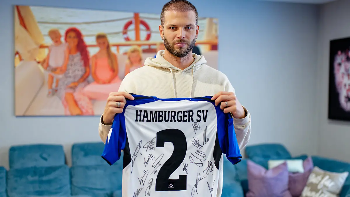 Der-ehemalige-Fussballspieler-Dennis-Diekmeier-haelt-in-seiner-Wohnung-ein-Trikot-des-Hamburger-SV-mit-dem-Namen-seiner-aeltesten-Tochter-Delani-in-den-Haenden