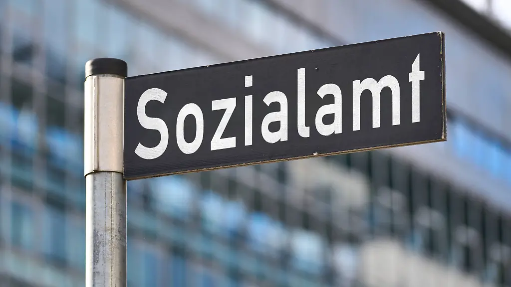 Bavaria-Germany-August-13-2025-PHOTOMONTAGE-street-sign-with-the-inscription-Social-Welfare-Office-in-front-of-a-modern-administrative-building-symbol-of-state-support-social-benefits-and-official-assistance-with-financial-and-social-problems-FOTOMONTAGE-Strassenschild-mit-der-Aufschrift-Sozialamt-vor-einem-modernen-Verwaltungsgebaeude-Symbol-fuer-staatliche-Unterstuetzung-Sozialleistungen-und-behoerdliche-Hilfe-bei-finanziellen-und-sozialen-Problemen