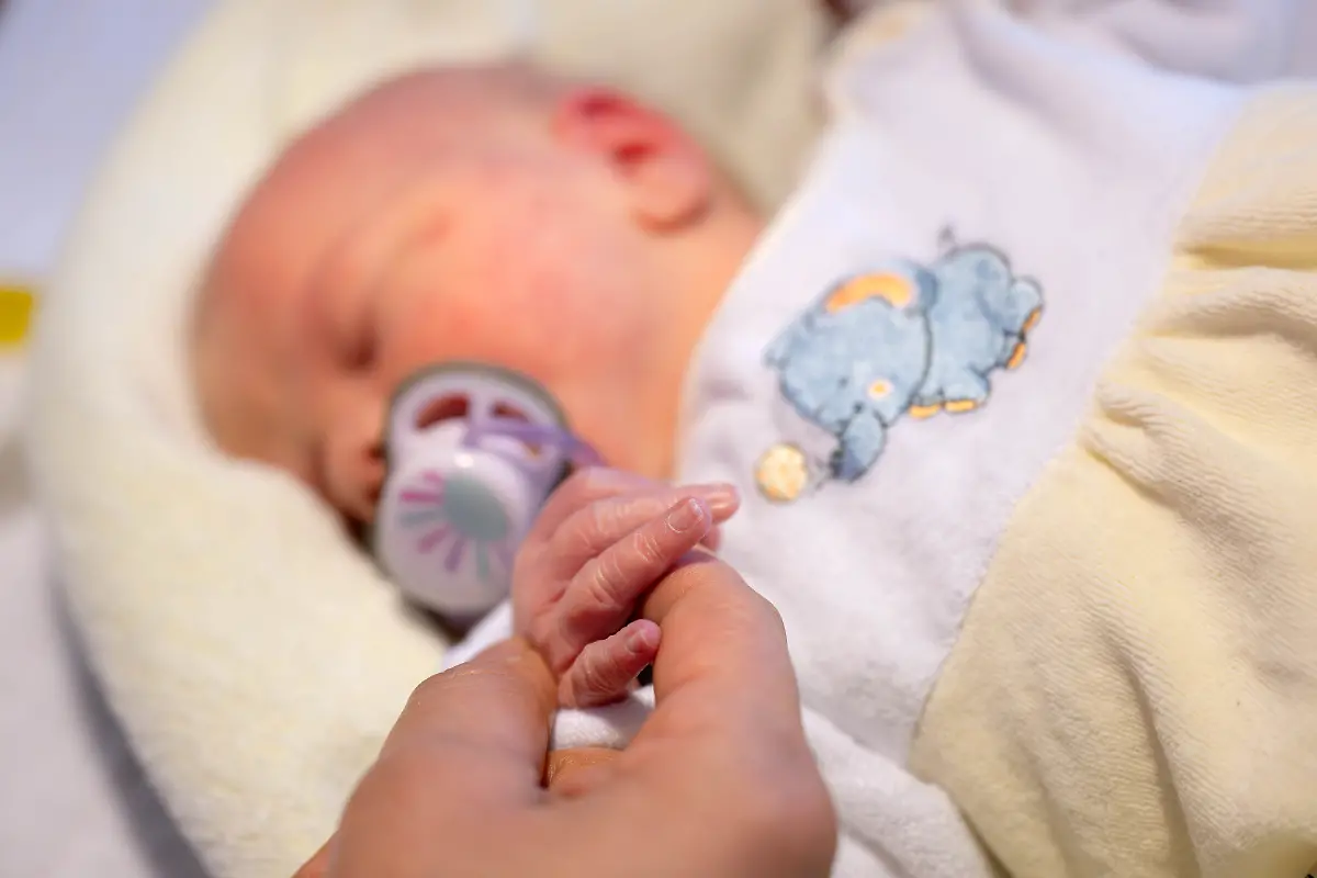 Eine-Hebamme-kuemmert-sich-um-einen-Saeugling-Mit-einem-Modellprojekt-in-einem-Krankenhaus-will-Bremen-die-Arbeitsbedingungen-fuer-Pflegekraefte-und-Hebammen-verbessern-Das-Projekt-Ich-pflege-wieder-weil-startete-Anfang-Februar-im-Krankenhaus-St-Joseph-Stift-in-Bremen-In-den-naechsten-vier-Jahren-sollen-dort-gemeinsam-mit-den-Pflegekraeften-und-Hebammen-bessere-Arbeitsbedingungen-im-Kreisssaal-und-auf-der-Woechnerinnenstation-erarbeitet-werden