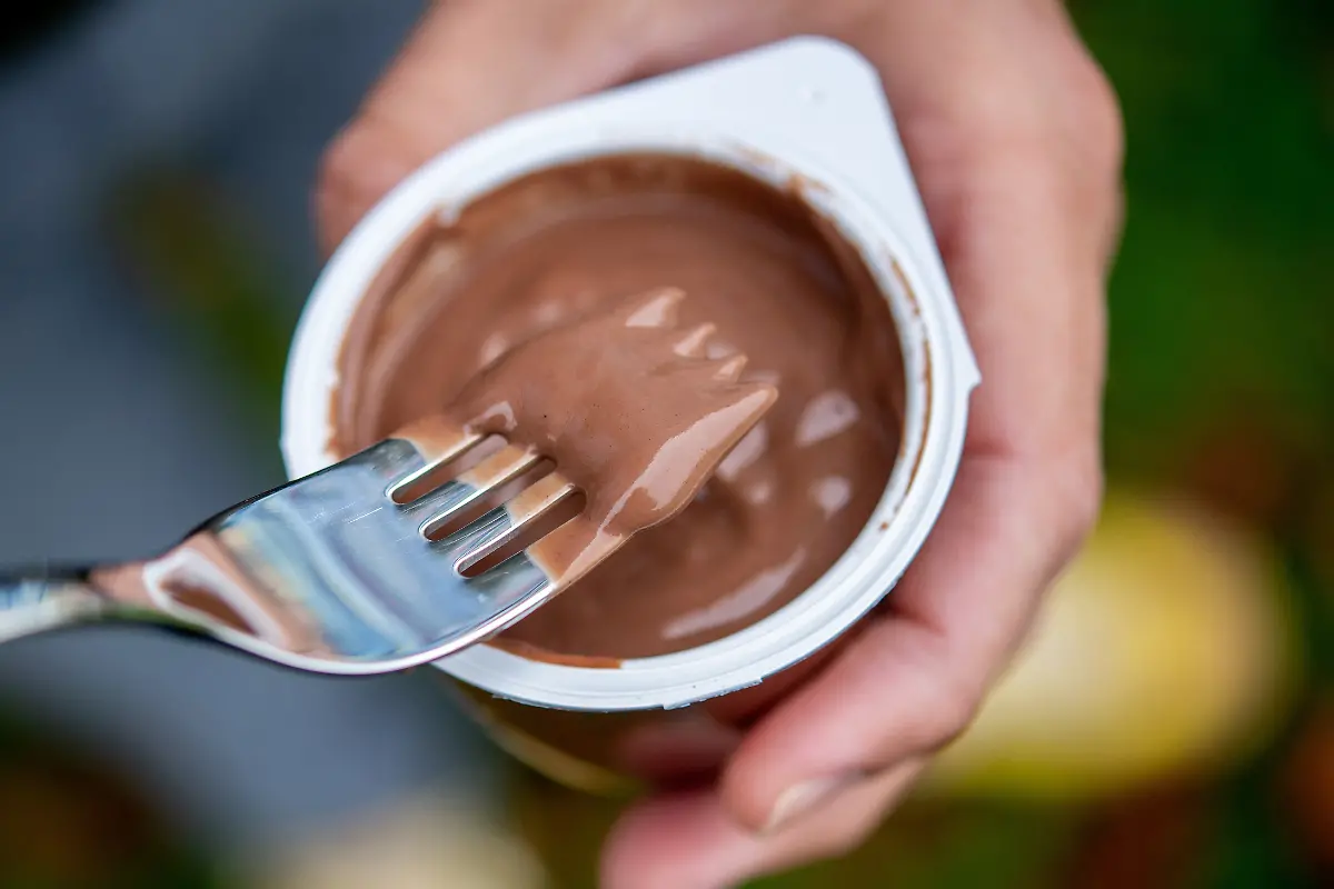 30-09-2025-Niedersachsen-Oldenburg-Ein-junger-Mann-isst-einen-Schokoladenpudding-mit-einer-Gabel-In-mehreren-deutschen-Staedten-treffen-sich-Menschen-um-gemeinsam-Pudding-mit-Gabeln-zu-essen-Bei-den-Aktionen-handelt-es-sich-um-einen-Internet-Trend