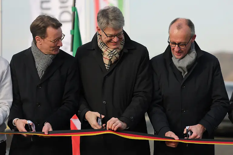 Hendrik-Wuest-l-r-CDU-Ministerpraesident-Nordrhein-Westfalen-Bundesverkehrsminister-Patrick-Schnieder-CDU-und-Bundeskanzler-Friedrich-Merz-CDU-durchschneiden-ein-Band-bei-der-Eroeffnung-der-Rahmedetalbruecke-Fast-vier-Jahren-war-im-Sauerland-die-wichtige-Nord-Sued-Achse-A45-wegen-einer-maroden-Bruecke-unterbrochen-Die-marode-Bruecke-war-Anfang-Dezember-2021-gesperrt-und-spaeter-gesprengt-worden