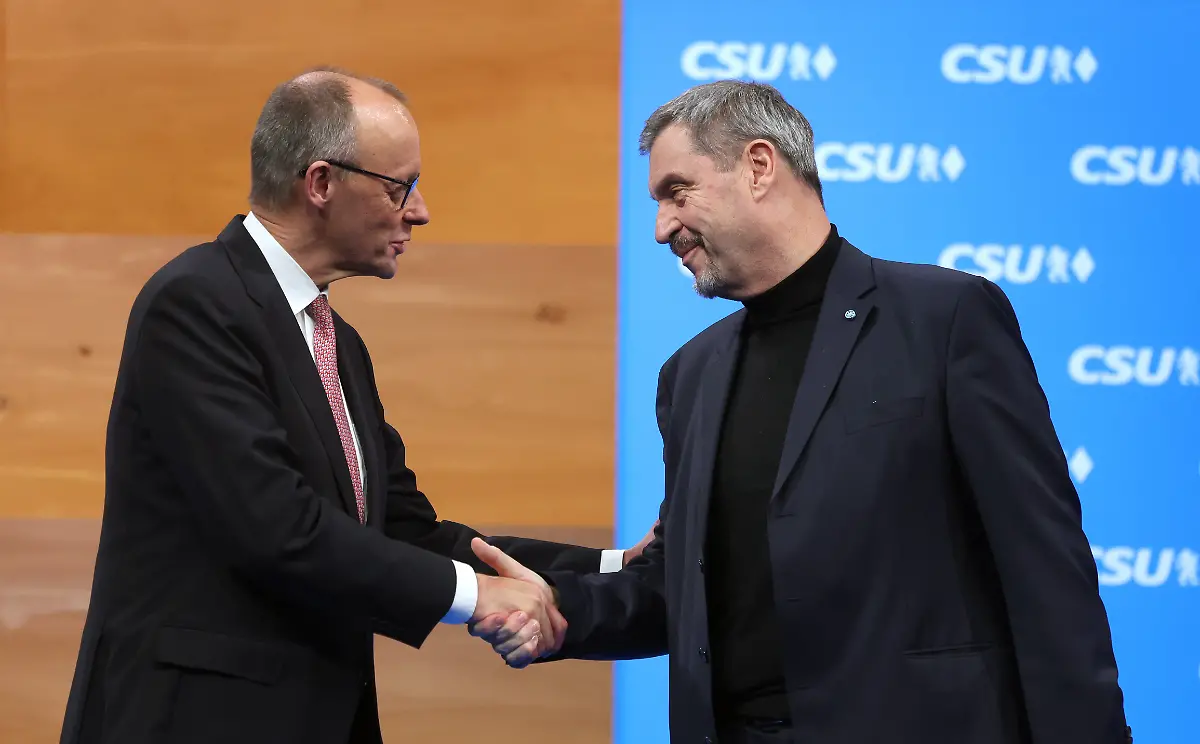 Bundeskanzler-Friedrich-Merz-CDU-l-und-Markus-Soeder-CSU-Vorsitzender-und-bayerischer-Ministerpraesident-stehen-beim-Parteitag-nach-der-Rede-des-Kanzlers-auf-der-Buehne