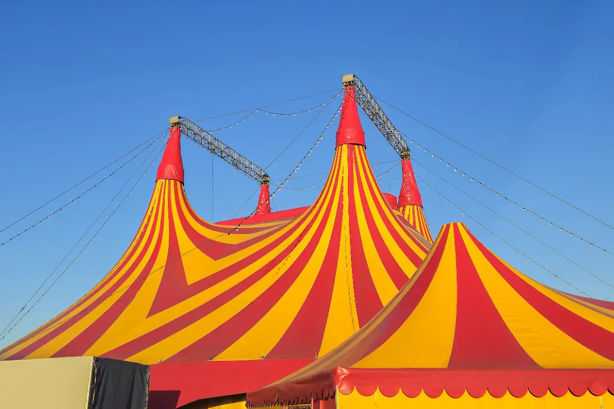 Colourful-circus-tent-the-dome-of-the-circus-on-the-background-of-the-blue-sky-Red-and-white-circus-tent-top