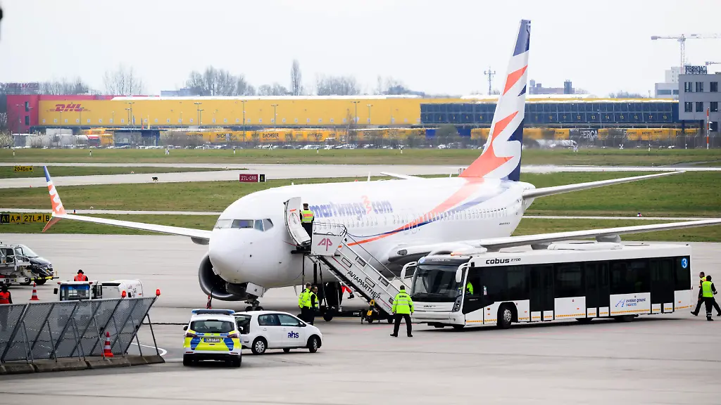 Polizei-und-ein-Bus-stehen-an-einem-Flugzeug-am-Flughafen-Hannover-Heute-Vormittag-ist-ein-Charterflug-aus-Islamabad-in-Hannover-gelandet-Auf-dem-Flug-befanden-sich-insgesamt-174-in-Afghanistan-besonders-gefaehrdete-Personen-denen-Deutschland-bereits-in-der-Vergangenheit-eine-Aufnahme-zugesagt-hatte