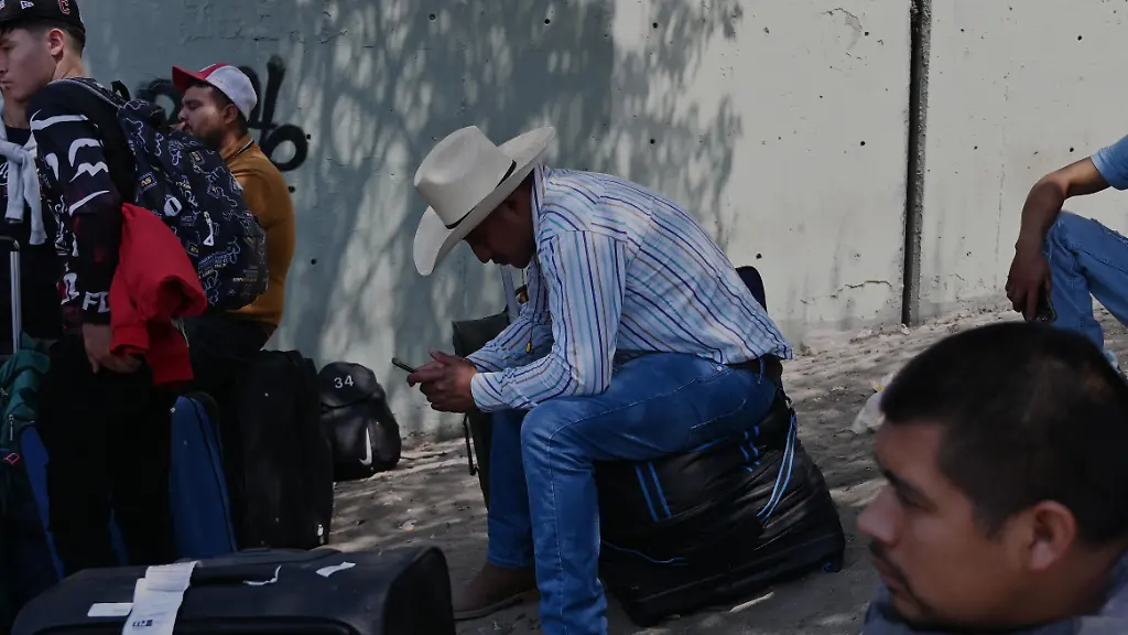 Mexican-laborers-with-work-visas-line-up-near-the-US-Mexico-Borders-San-Ysidro-Port-of-Entry-in-Tijuana-Mexico-on-Wednesday-August-13-2025-Following-ICE-raids-in-the-United-States-there-s-a-notable-shortage-of-day-laborers-particularly-in-industries-relying-on-undocumented-workers-like-field-workers-in-agriculture-Most-of-the-Mexican-laborers-that-were-lined-up-waiting-to-cross-to-San-Diego-California-are-heading-to-the-US-state-of-Washington-to-work-in-the-states-ample-apple-orchards