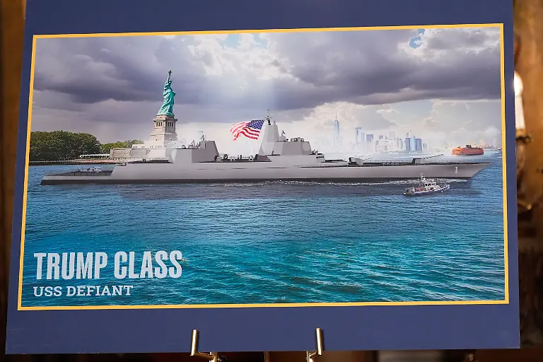 22-12-2025-USA-Palm-Beach-Ein-Bild-mit-Kriegsschiff-ist-zu-sehen-bevor-Praesident-Donald-Trump-in-seinem-Club-Mar-a-Lago-spricht-US-Praesident-Donald-Trump-hat-den-Bau-von-zwei-neuen-Kampfschiffen-fuer-die-Marine-angekuendigt-Die-Baureihe-soll-seinen-Namen-tragen-Trump-Class