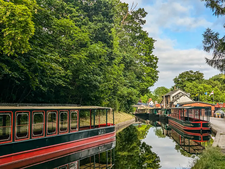 19-06-2025-Lllangollen-Schmalboote-auf-dem-Llangollen-Kanal-in-Wales-UK-umgeben-von-ueppigem-Gruen-und-ruhigem-Wasser