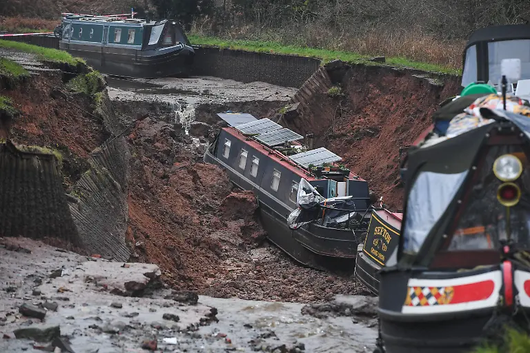 Blick-auf-einen-Erdrutsch-durch-das-grosse-Mengen-Wasser-in-das-Chemiegebiet-in-Whitchurch-gelangen-Rettungsdienste-hatten-den-Grossunfall-gemeldet-nachdem-mehrere-Meldungen-bei-ihnen-eingingen-Zehn-Menschen-wurden-in-Sicherheit-gebracht-nachdem-ein-50-Meter-langes-Sinkloch-in-einen-Kanal-in-Shropshire-durchbrochen-und-mehrere-schmale-Boote-auf-Grund-gesetzt-hatte