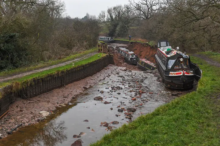 Whitchurch-sinkhole-The-scene-in-Whitchurch-Shropshire-where-emergency-services-have-declared-a-major-incident-after-receiving-reports-at-4-22am-this-morning-of-a-sinkhole-causing-large-volumes-of-water-to-escape-onto-land-in-the-Chemistry-area-of-Whitchurch-Ten-people-have-been-helped-to-safety-after-a-50-metre-long-sinkhole-breached-a-canal-in-Shropshire-leaving-several-narrow-boats-stranded-Picture-date-Monday-December-22-2025